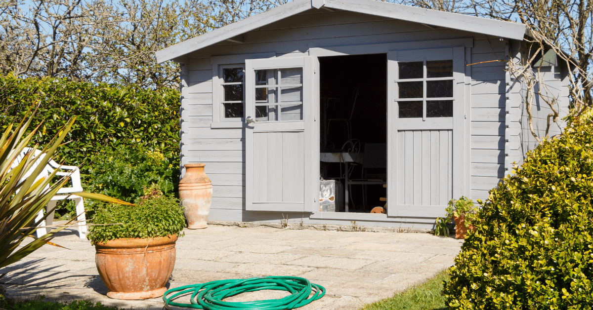 A grey shed with door open.