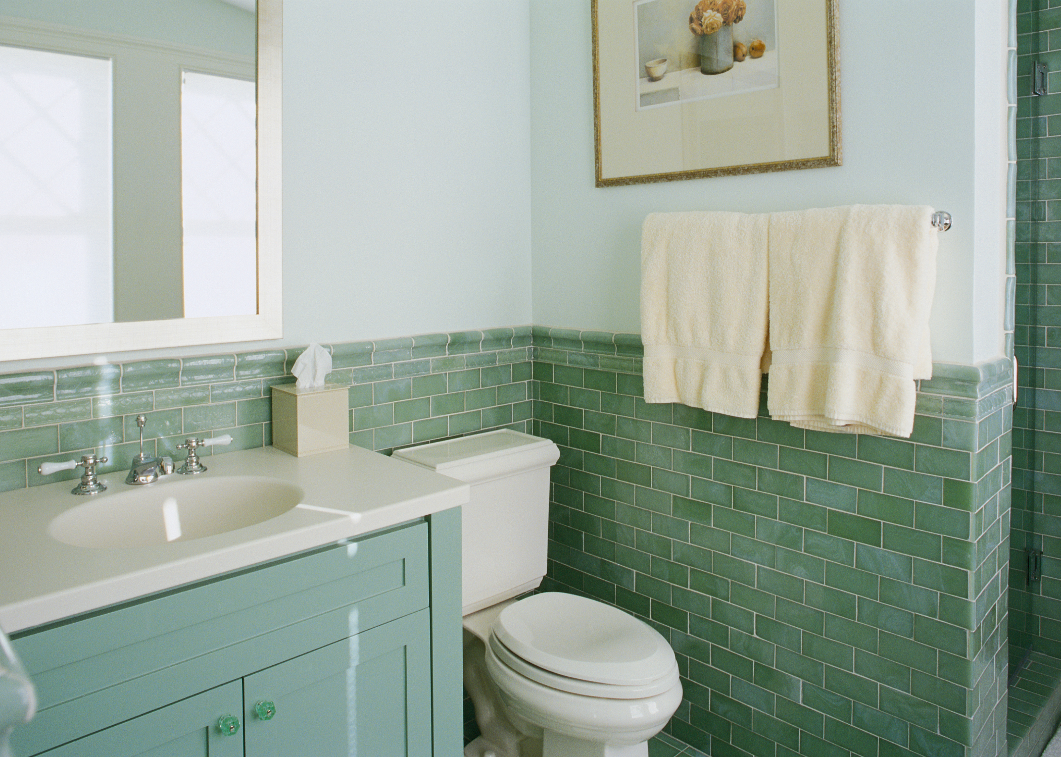 3/4 bathroom with green tiles and vanity