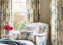 Bedroom features a yellow and blue floral chaise lounge with caster legs and yellow and blue floral curtains