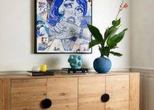 Blue pop art hangs over a styled chunky reclaimed wood credenza.