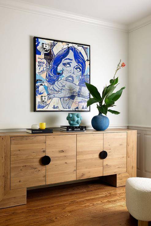 Blue pop art hangs over a styled chunky reclaimed wood credenza.