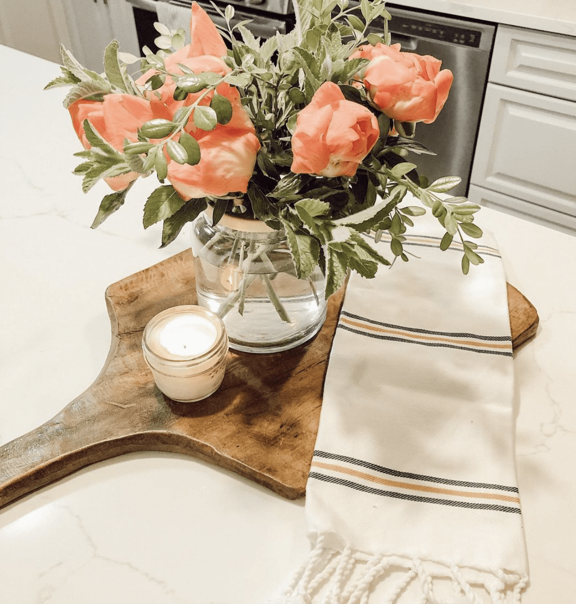 marble countertop with wood cutting board and flower arrangement