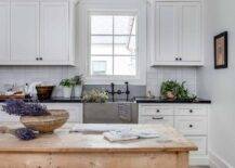 White cottage kitchen boasts a freestanding farmhouse island.