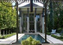 A black metal pergola is featured next to a rectangular in ground pool.