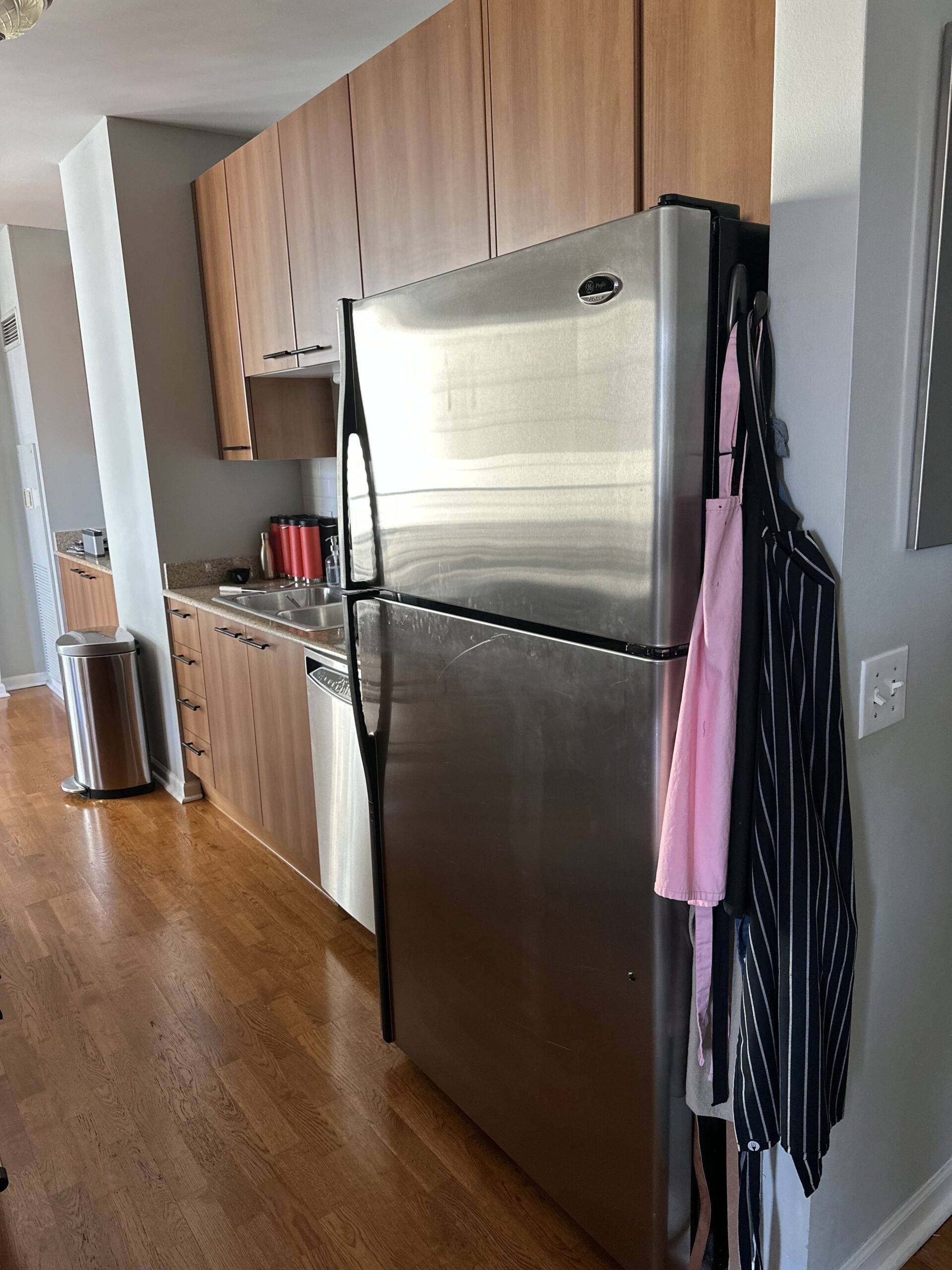 Stainless steel fridge in a small kitchen.