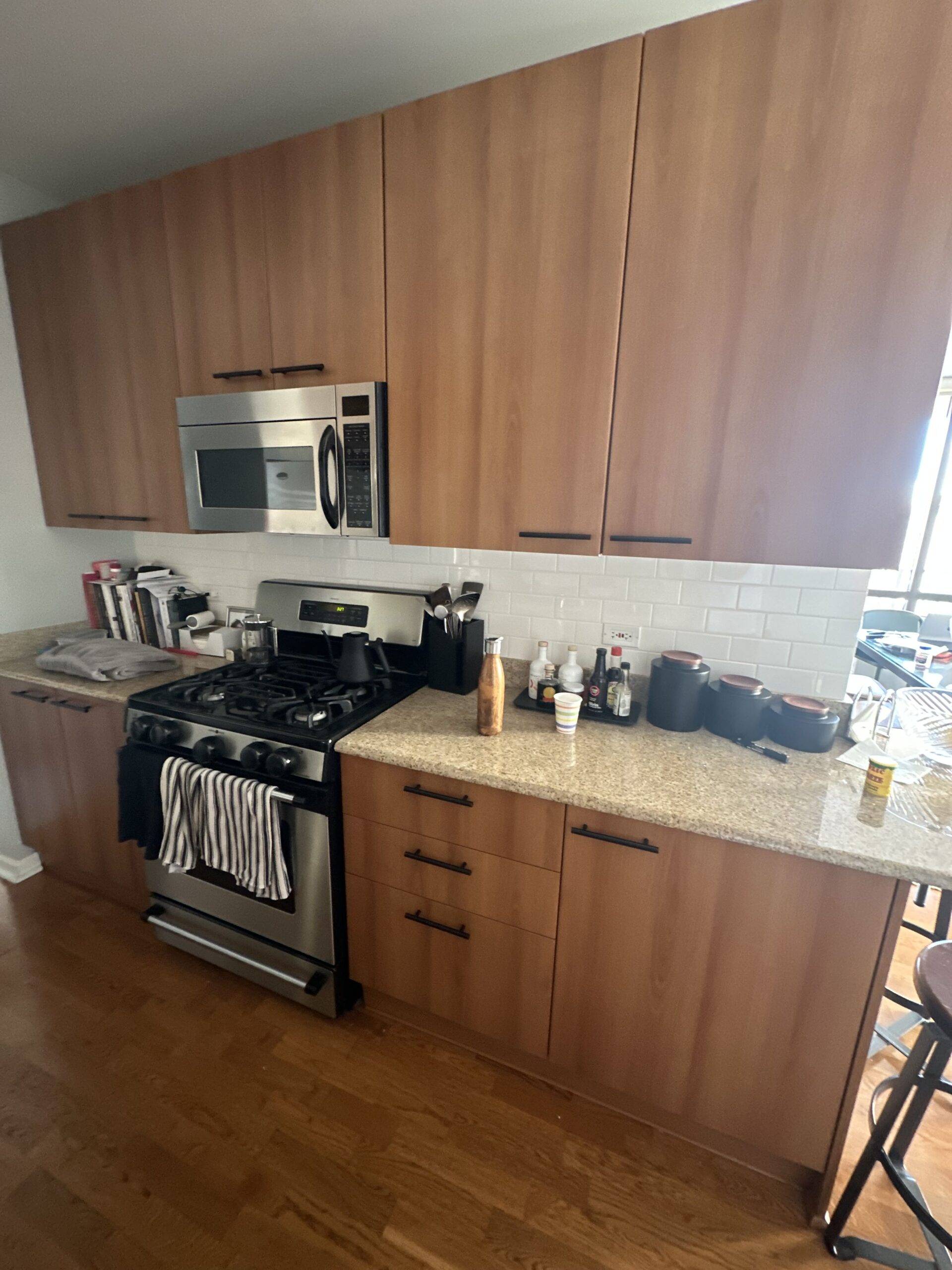 Outdated kitchen with wooden cabinets and flooring.