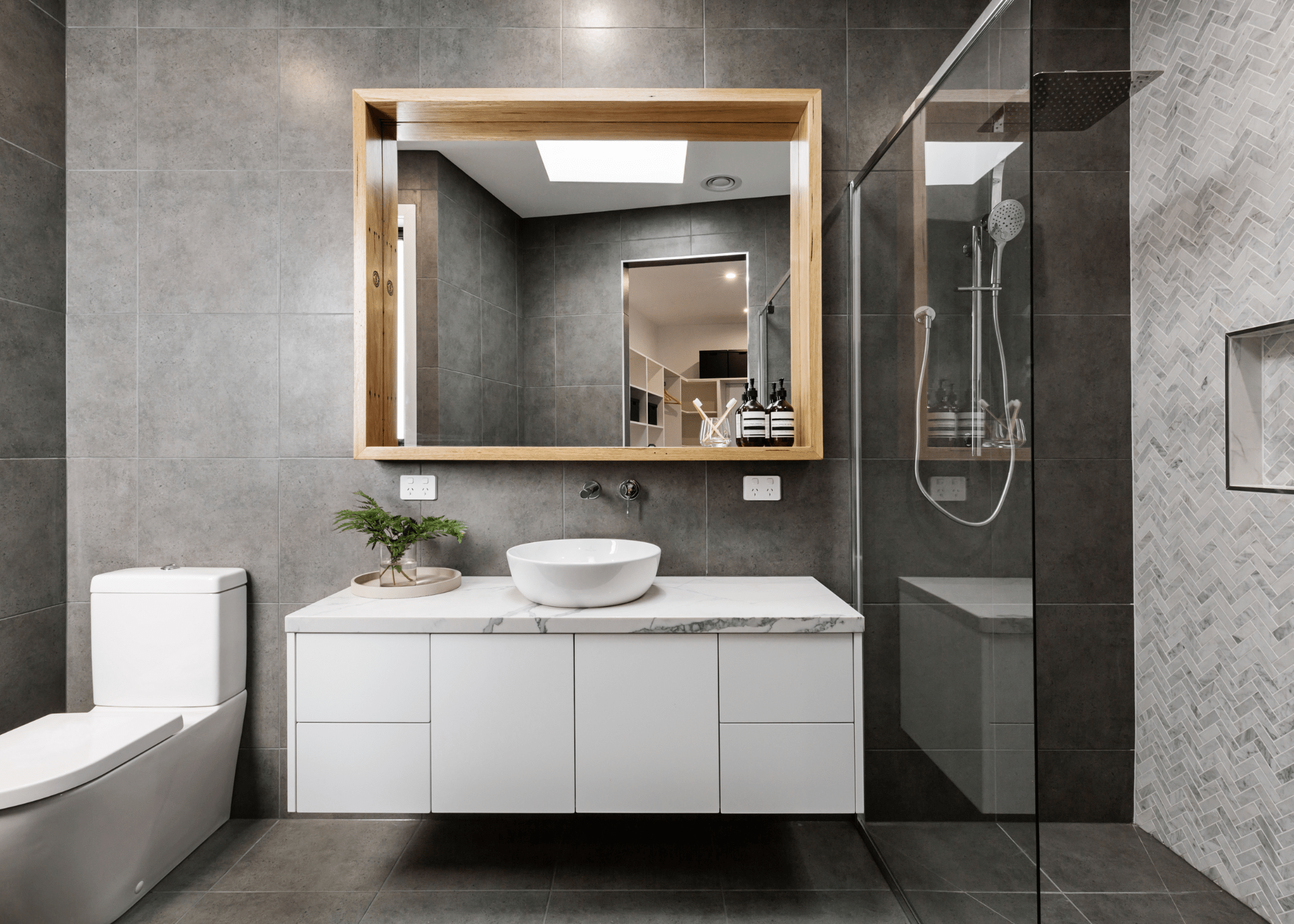 grey modern bathroom with wood frame mirror and white floating vanity