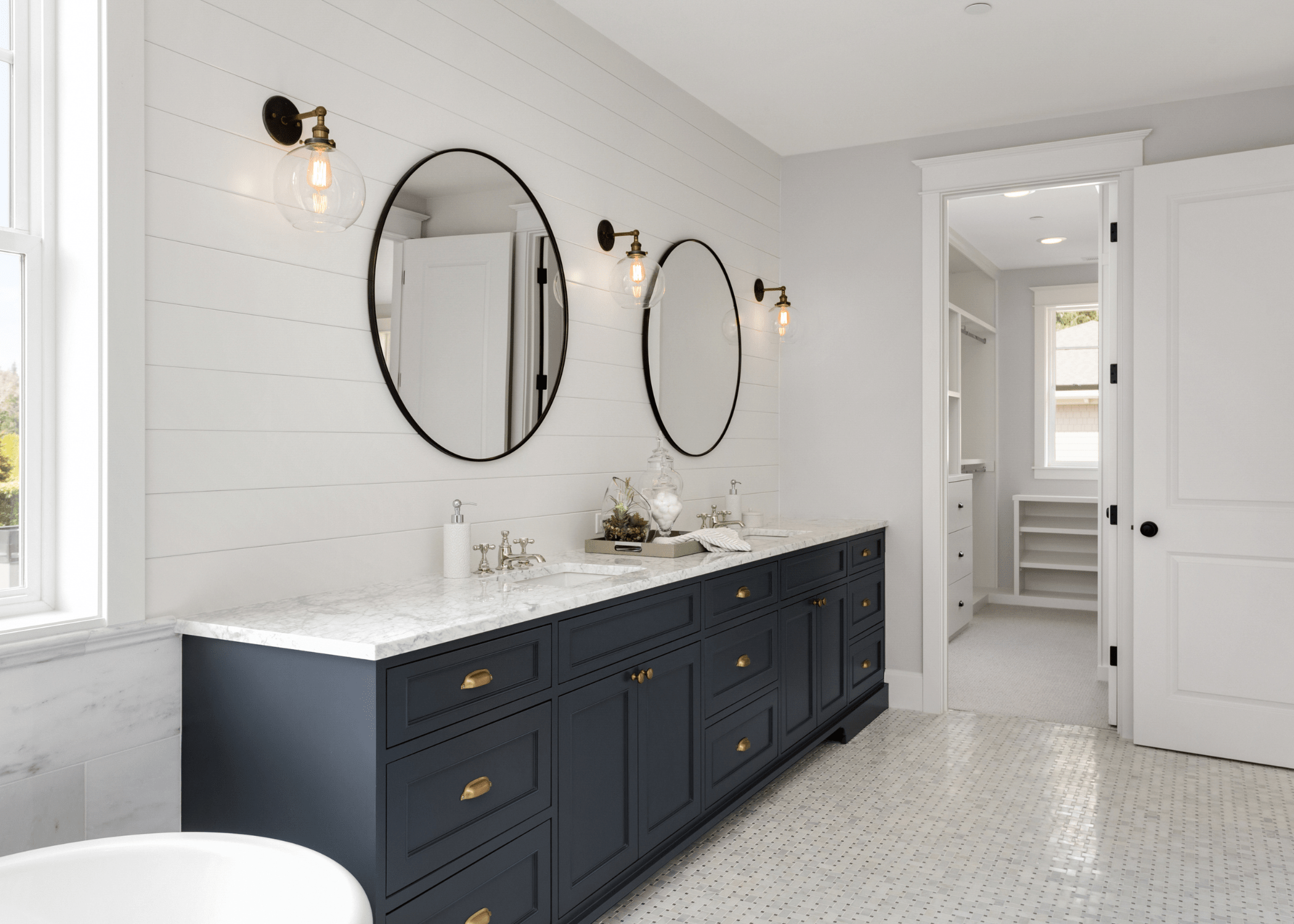 modern luxury bathroom with circle mirrors and dark colored vanity