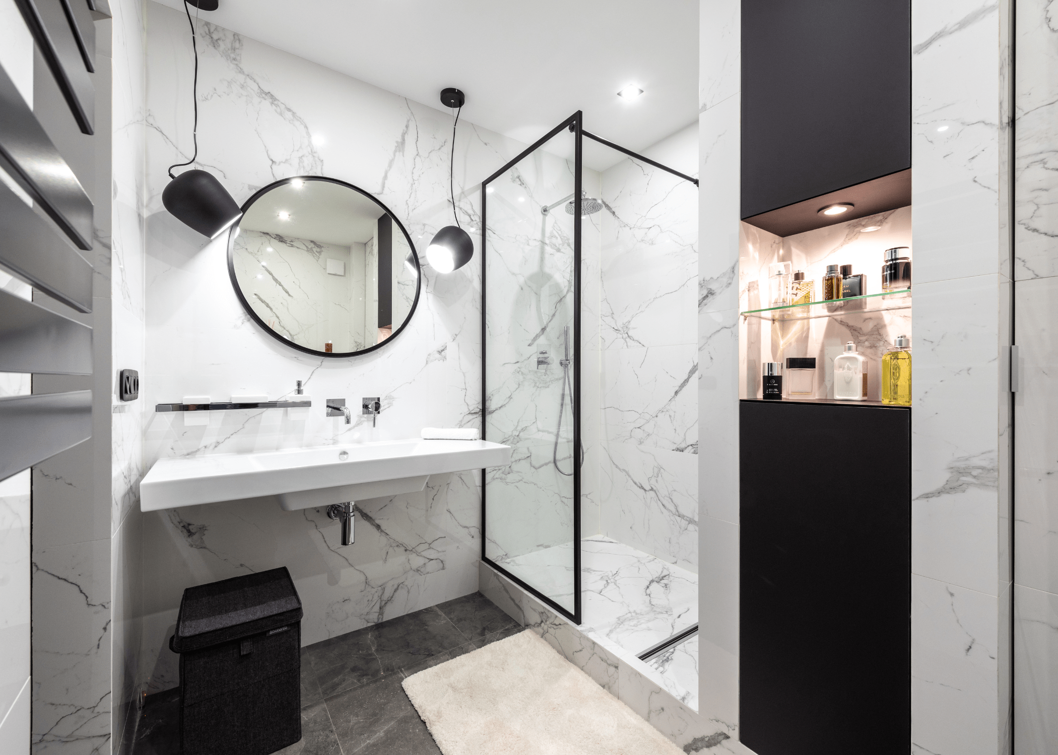 black and white bathroom with round circle mirror and walk in shower