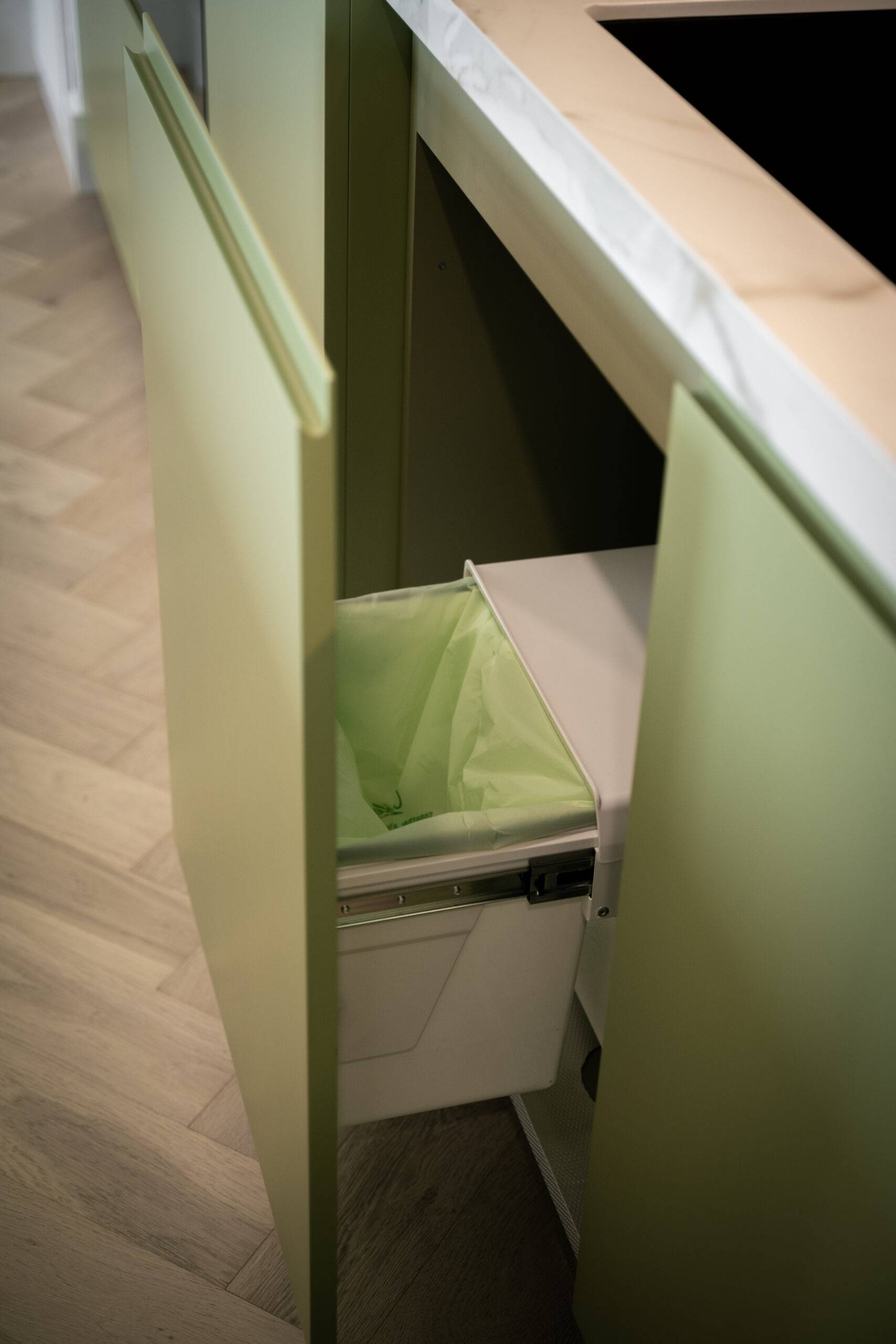 Sage green pull out garbage bins.