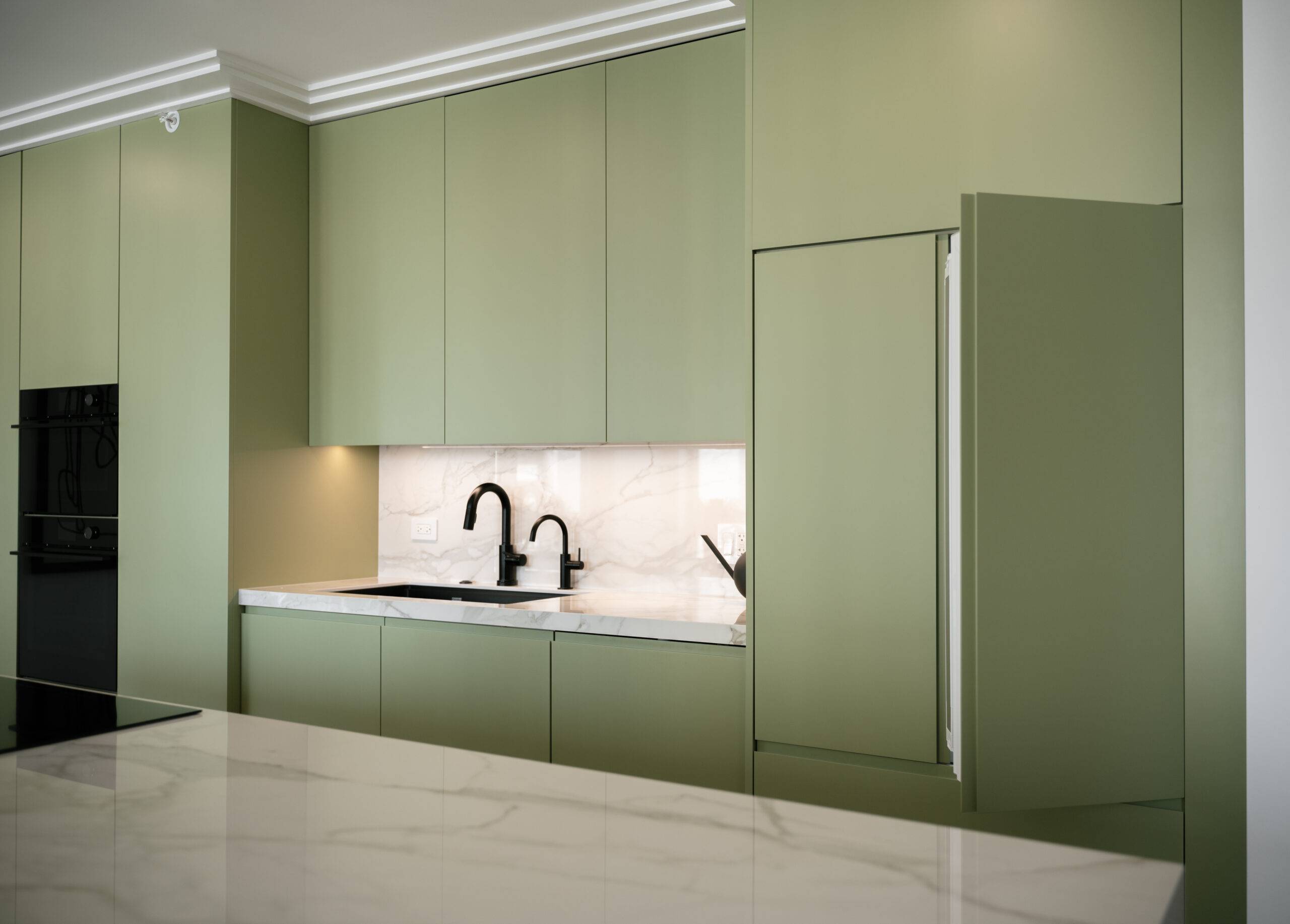 Marble countertop in a sage green kitchen.