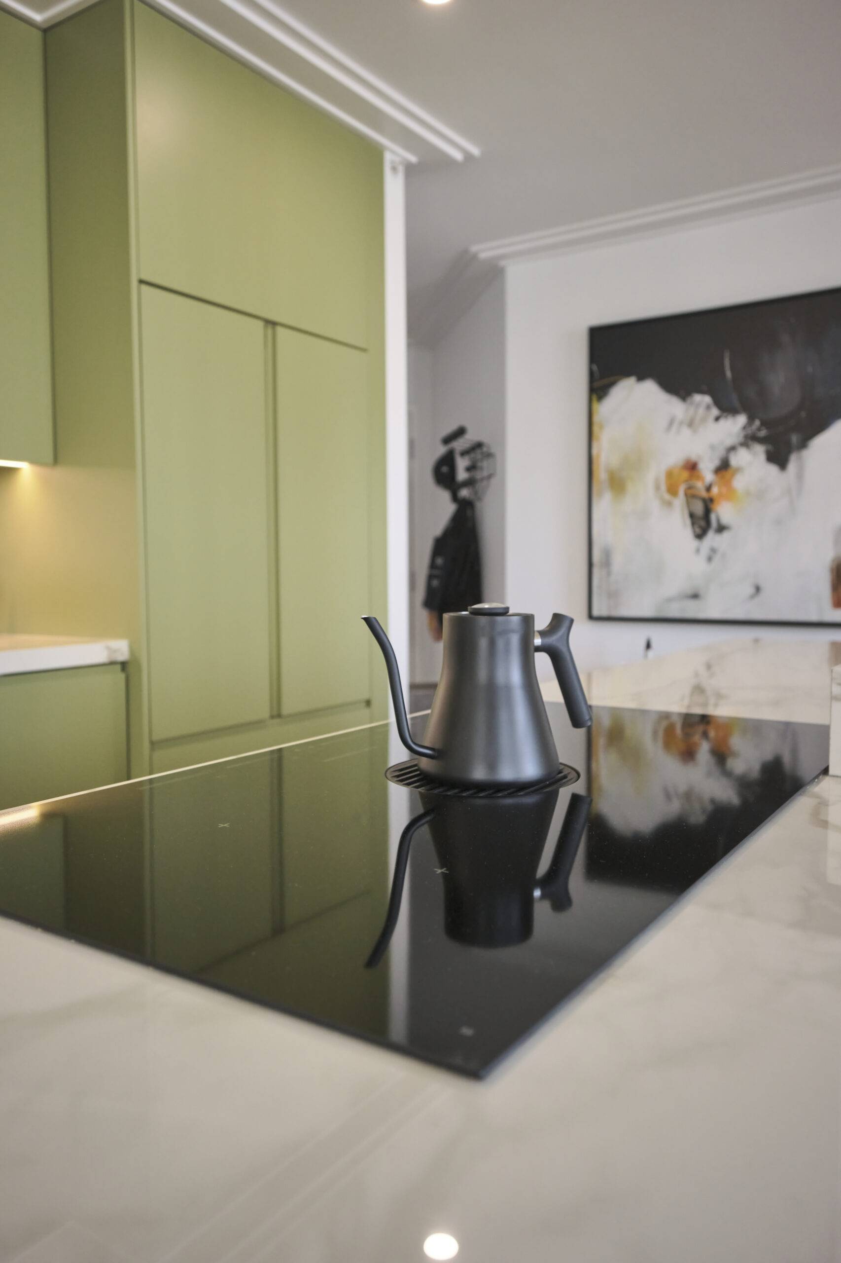 Glass stove top in a sage green kitchen.