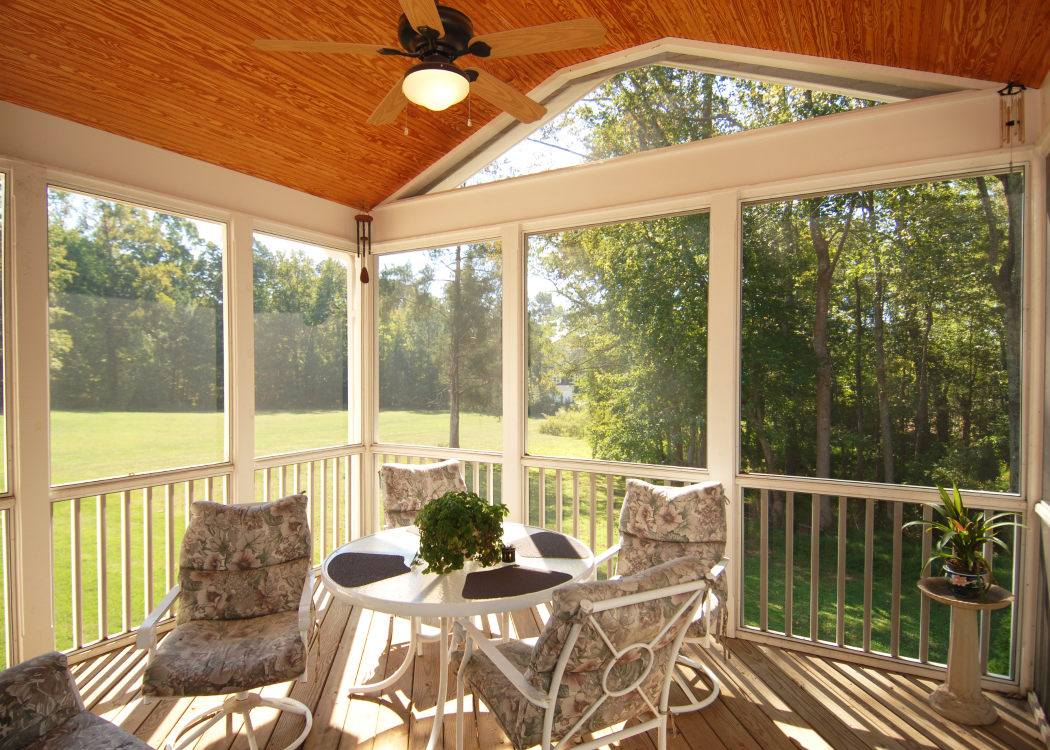 screened in porch with wood ceiling and white patio furniture