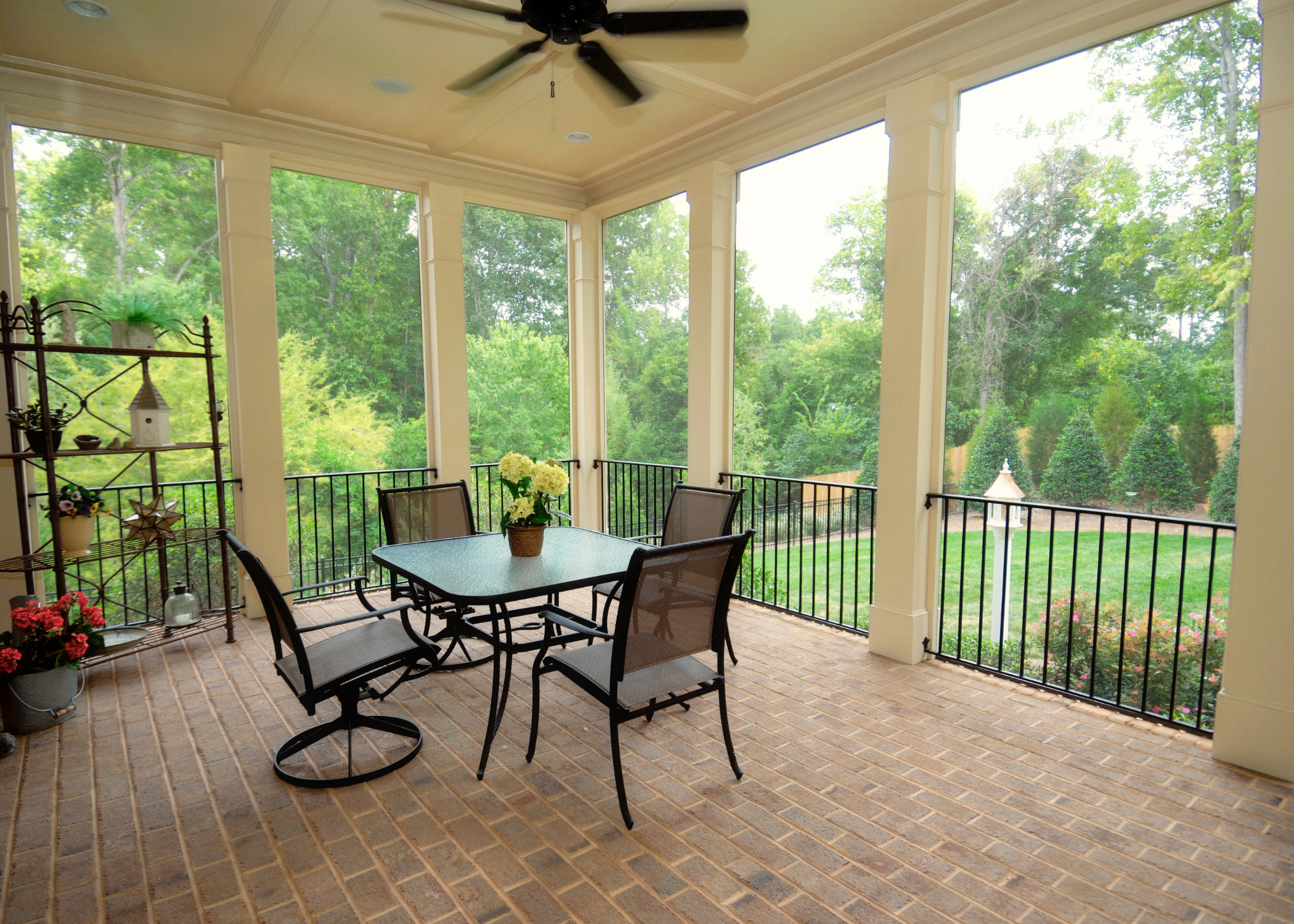 screened in patio with white pillars and black patio furntiure