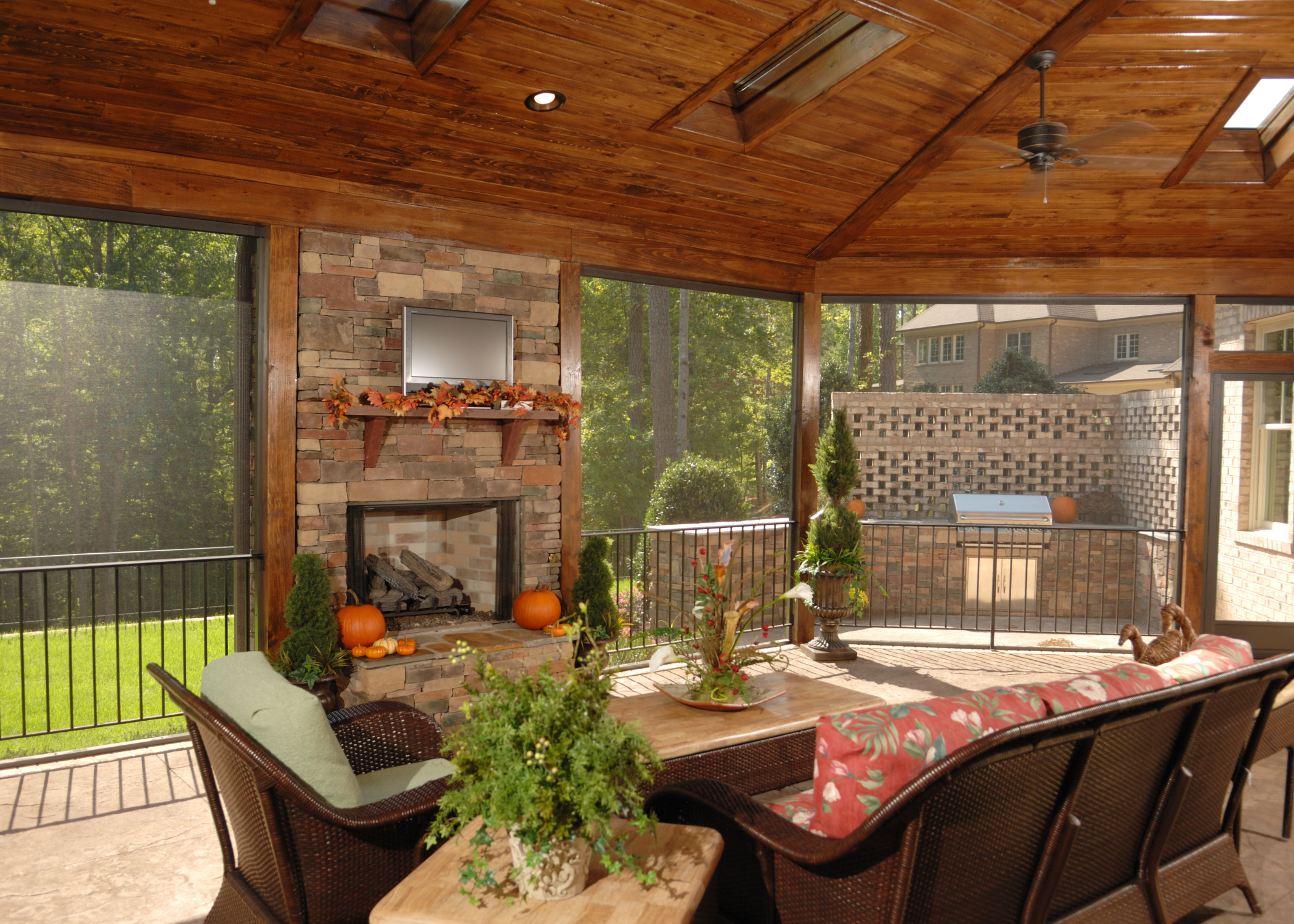 screened in patio with wood ceiling and brick fireplace