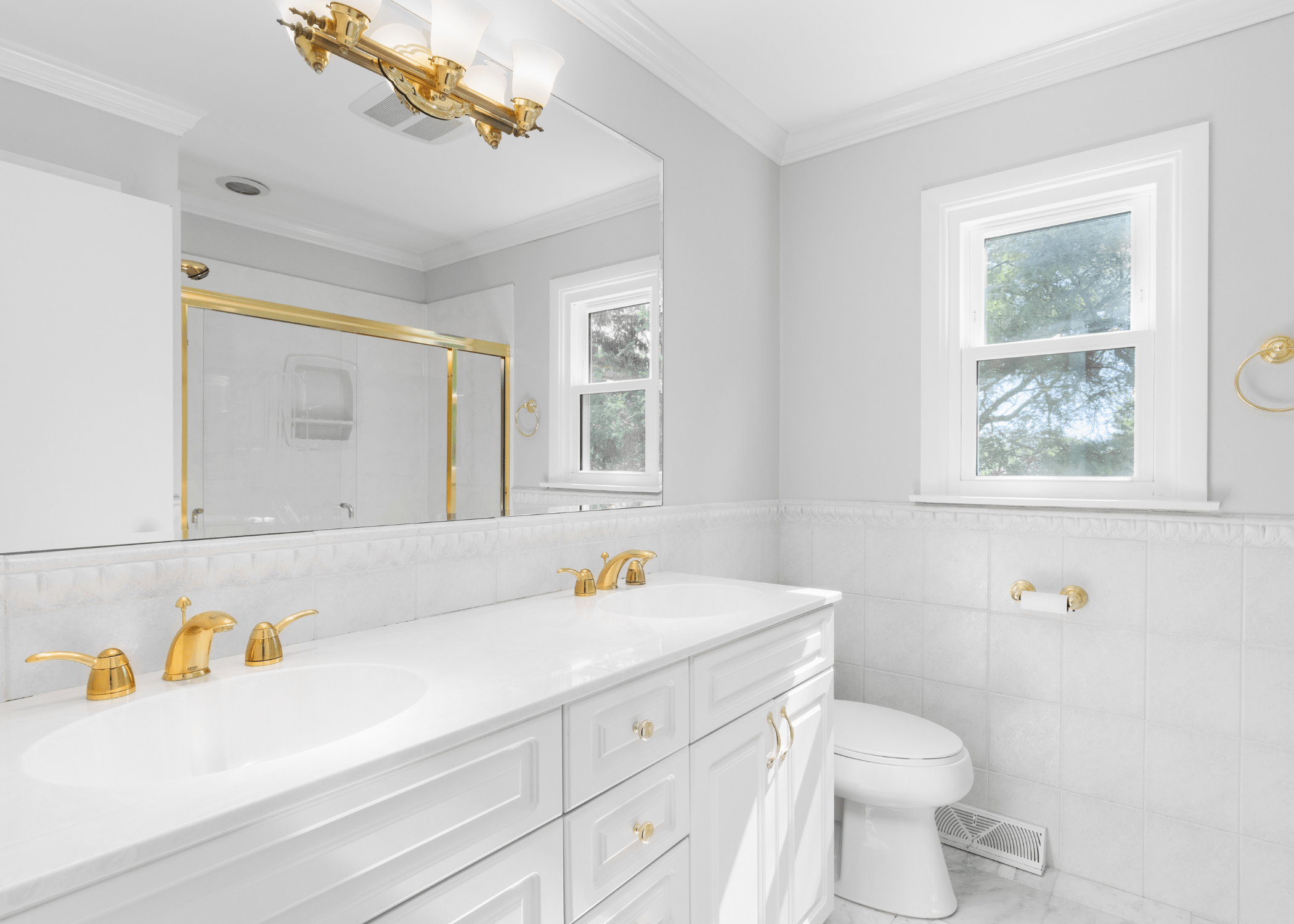 white bathroom with gold fixtures and white trim.