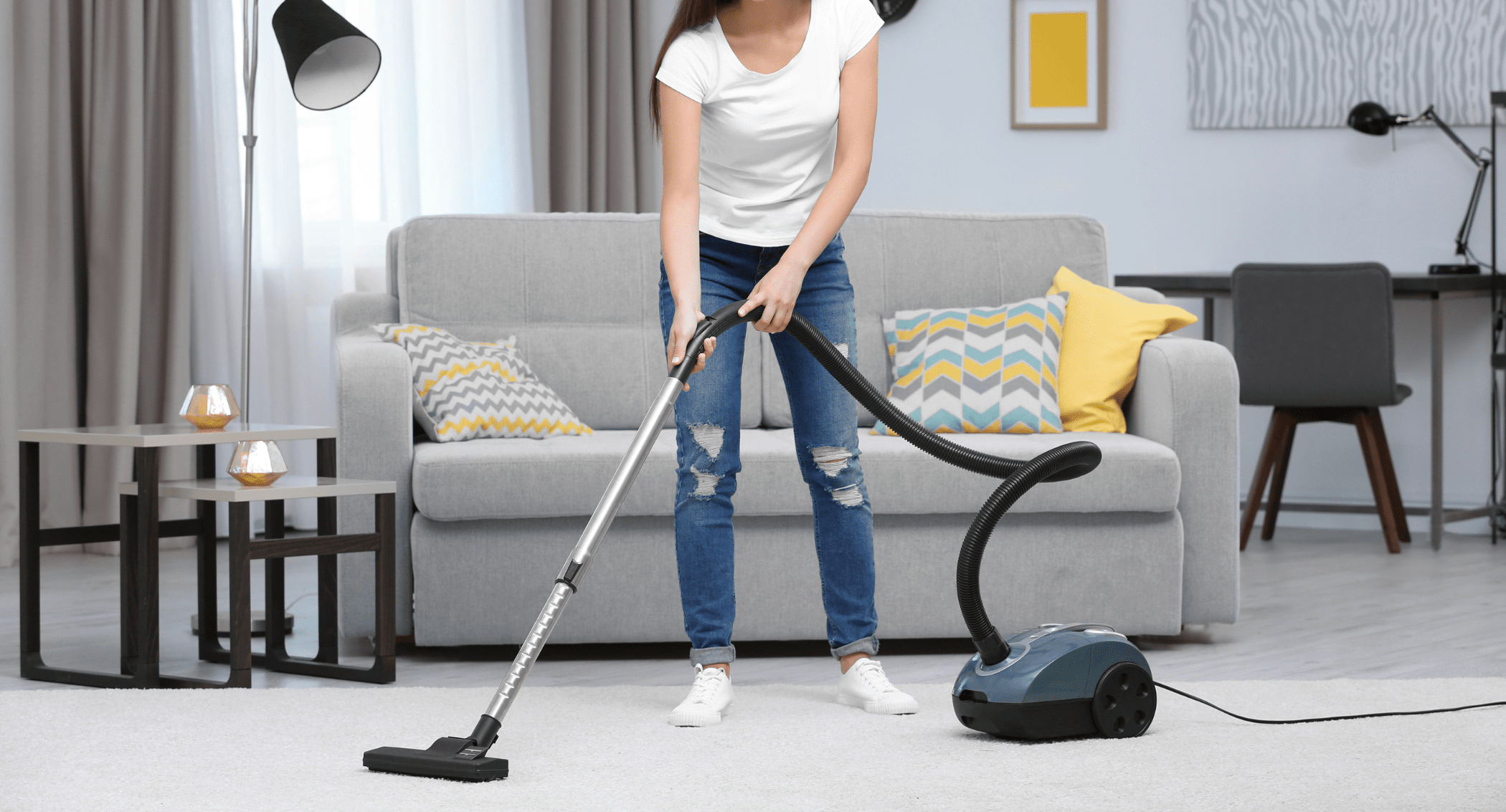 woman vacuuming in front of couch