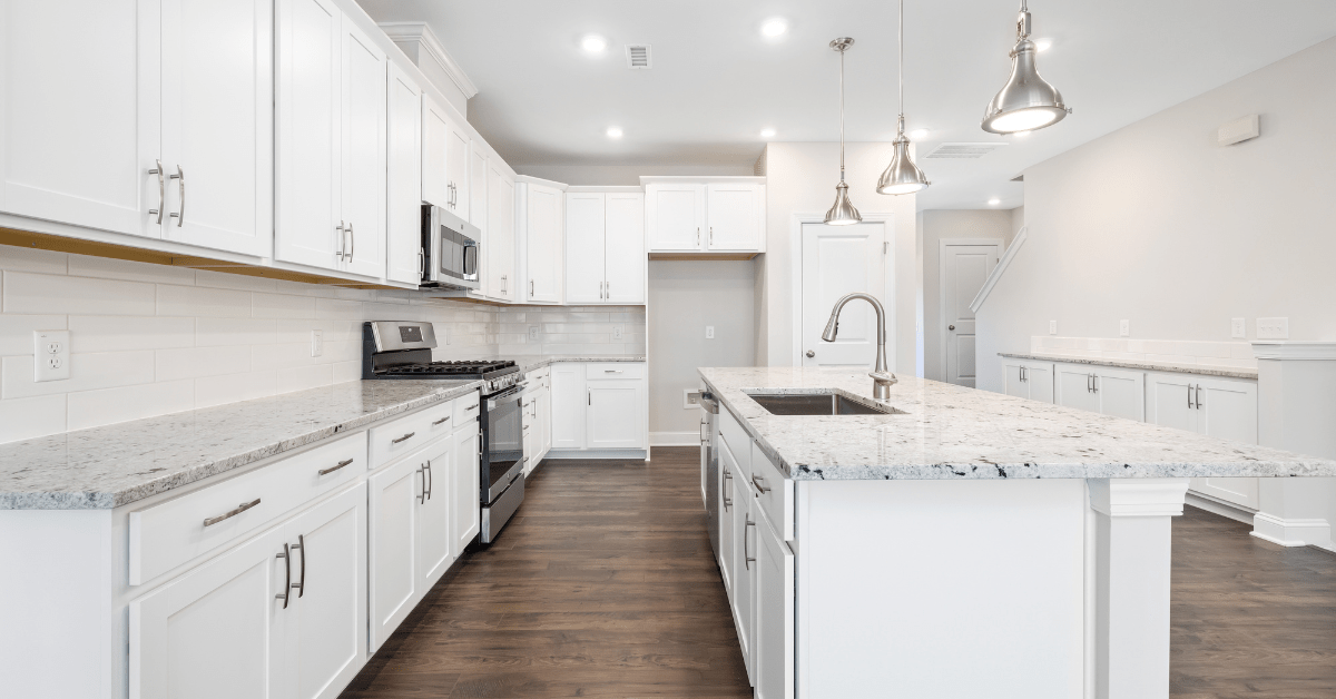 Marble counters in a modern kitchen with white cabinets.