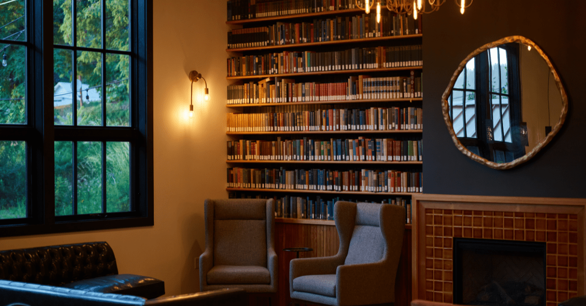 Cozy room with bookshelf that reaches the ceiling.