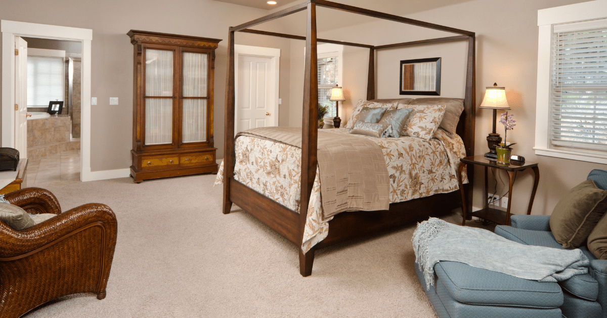 A bedroom with four poster bed.