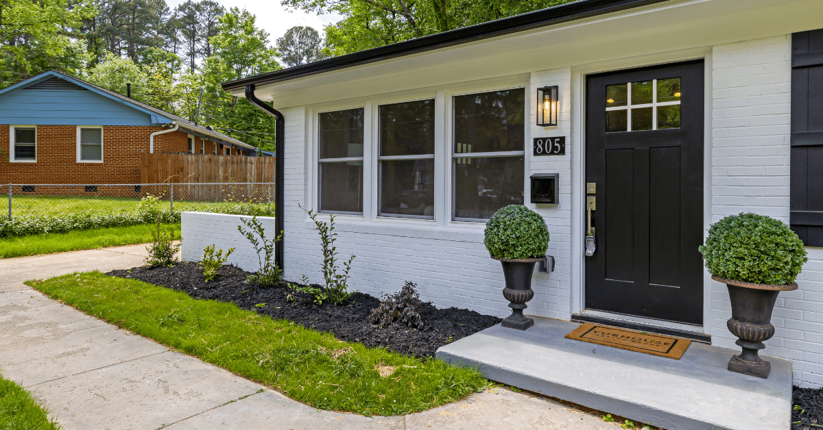 Small house with a large black front door.