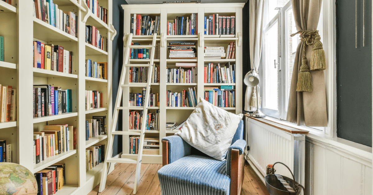 Small room with floor-to-ceiling bookshelves and chair.