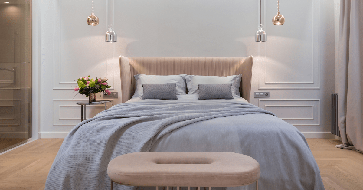 Pastel colored bedroom with light fixtures on either side.