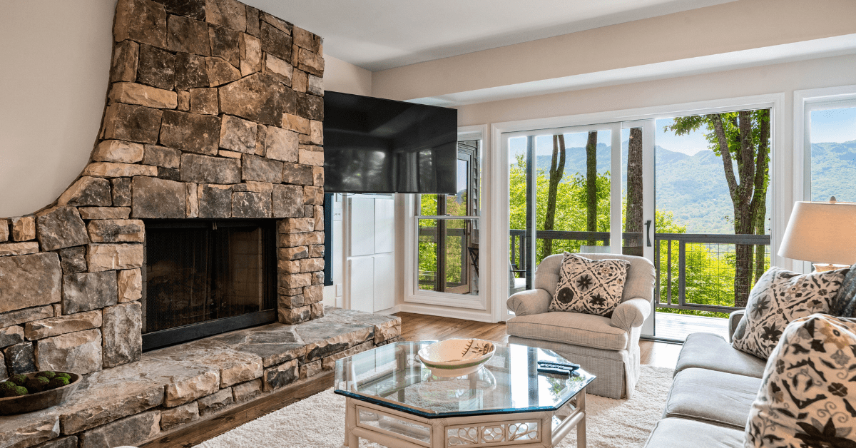 Unique stone floor to ceiling fireplace with TV integrated beside it.