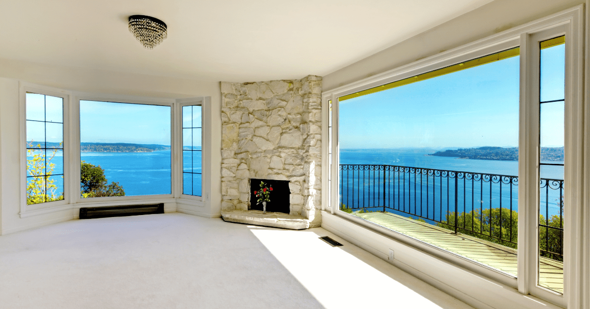 Empty living room with a white floor to ceiling fireplace.