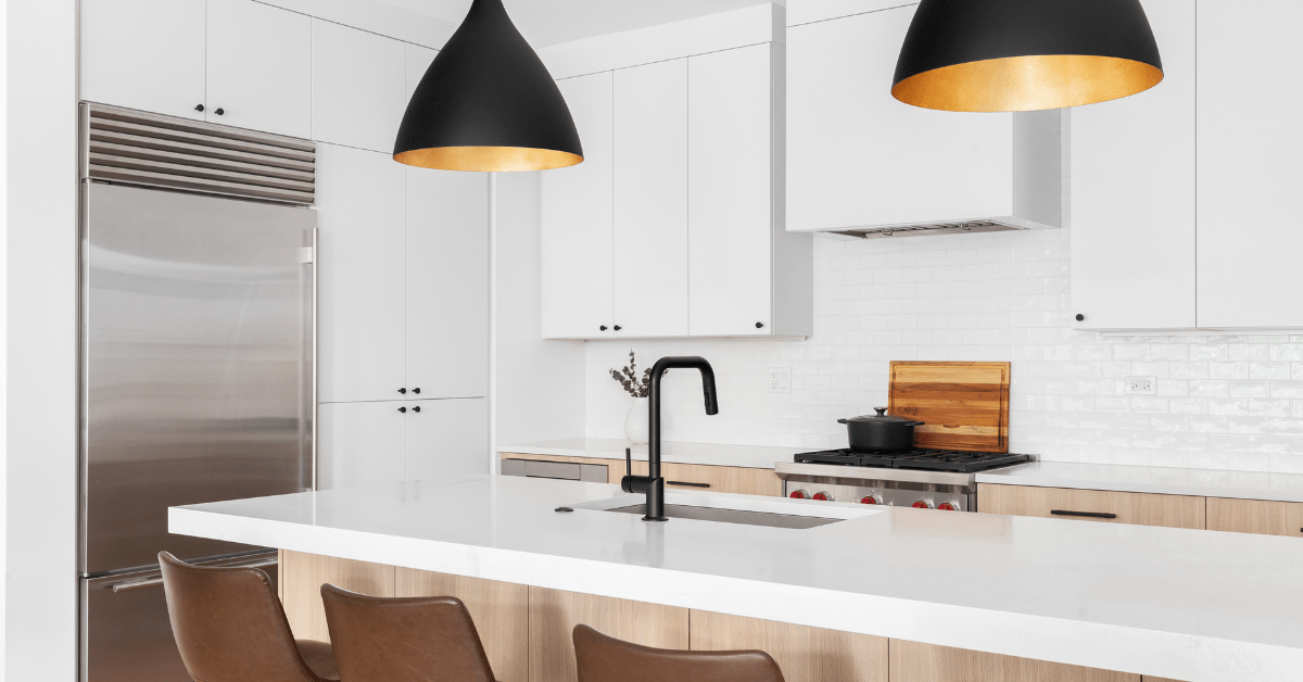 Overhead lighting in a modern kitchen with white cabinets.