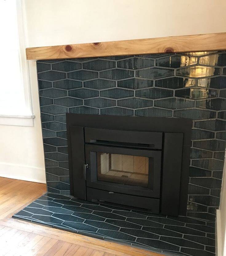 Teal colored fireplace tile with wooden shelf.