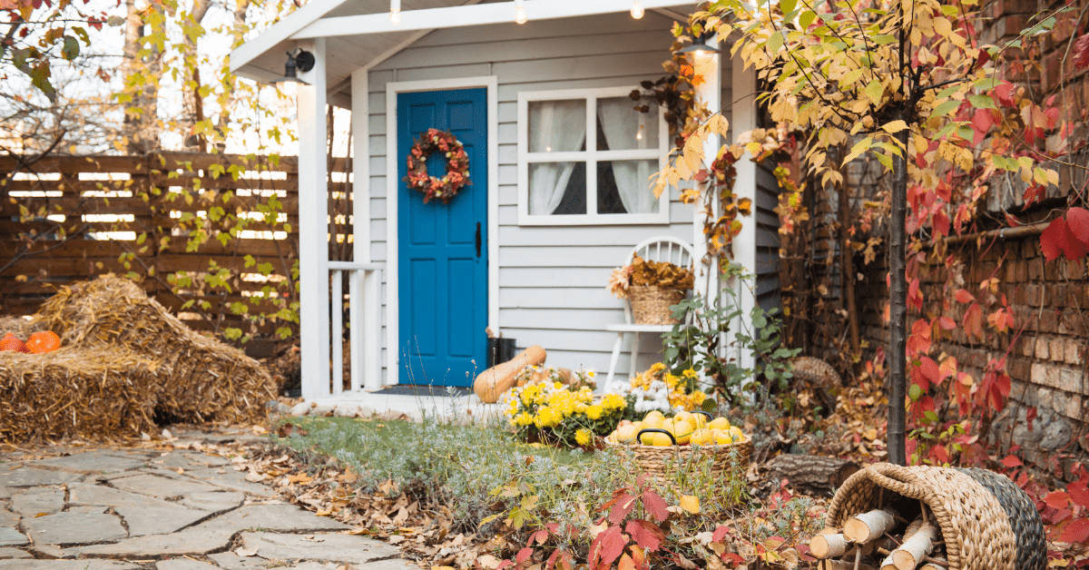 Front yard with fall leaves and pumpkins.