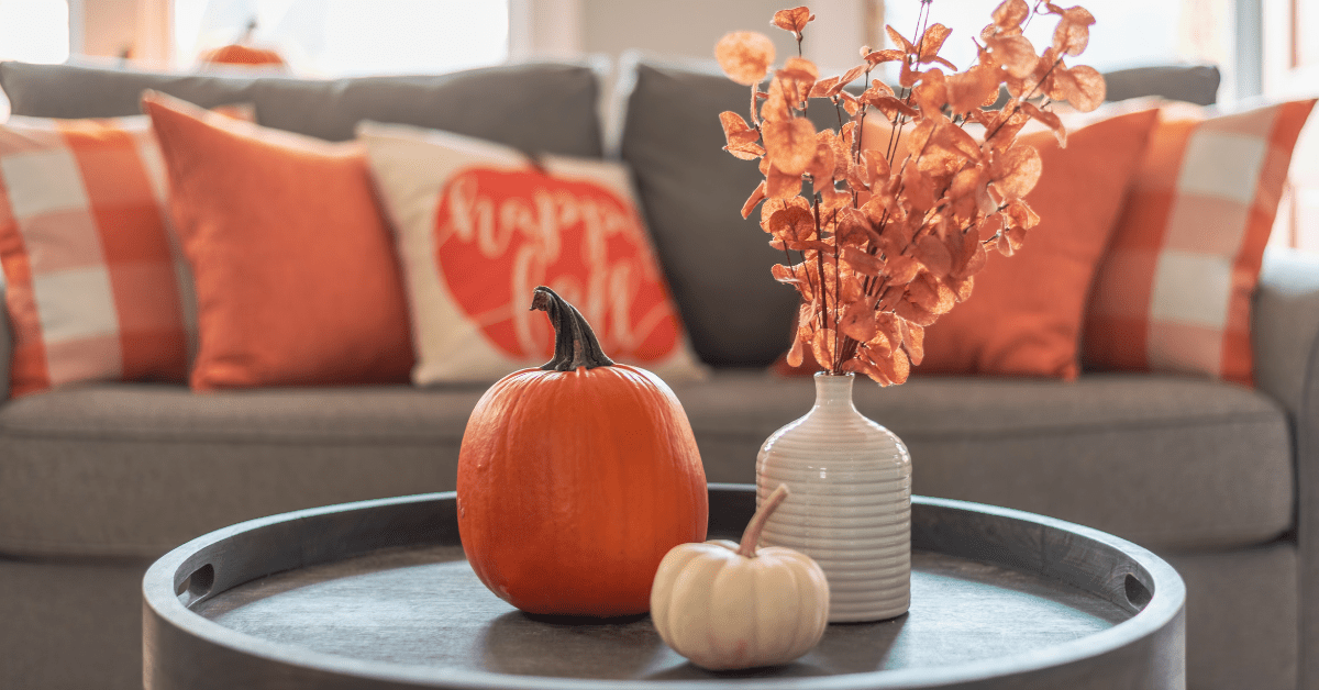 Fall pumpkin decor and orange throw pillows.