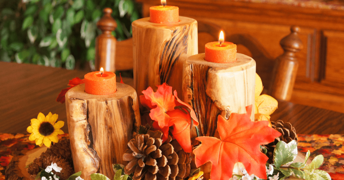 Candles surrounded by fall centerpiece decor.