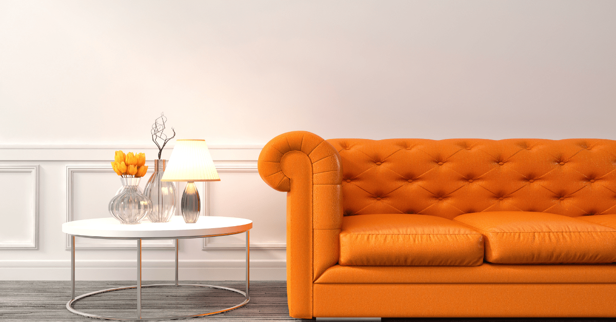 An orange couch in a white living room.