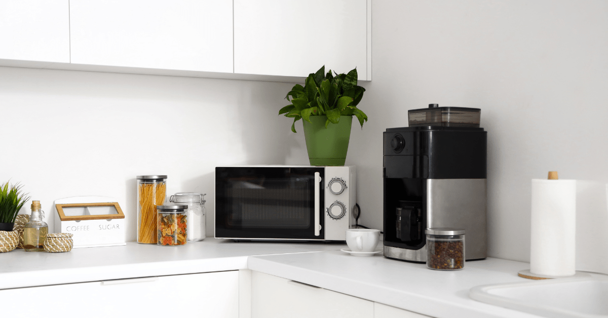 Coffee machine and microwave on kitchen countertops.