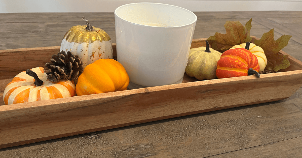 Wooden tray with candle and fall decor.