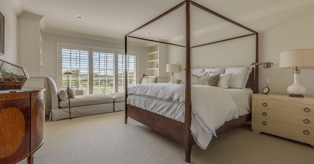 Four post bed in a large bedroom.