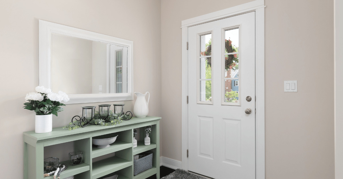 Green narrow table in a white entryway.