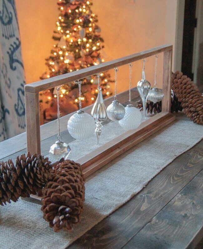 Christmas ornaments hanging from wooden frame.