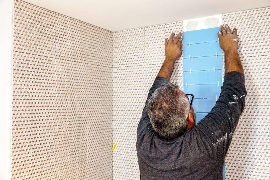 Contractor installing bathroom tile