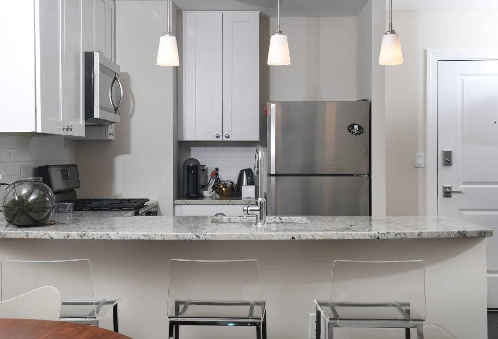 Laura Kiker's kitchen has granite counter tops, stainless steel appliances and pendant lighting