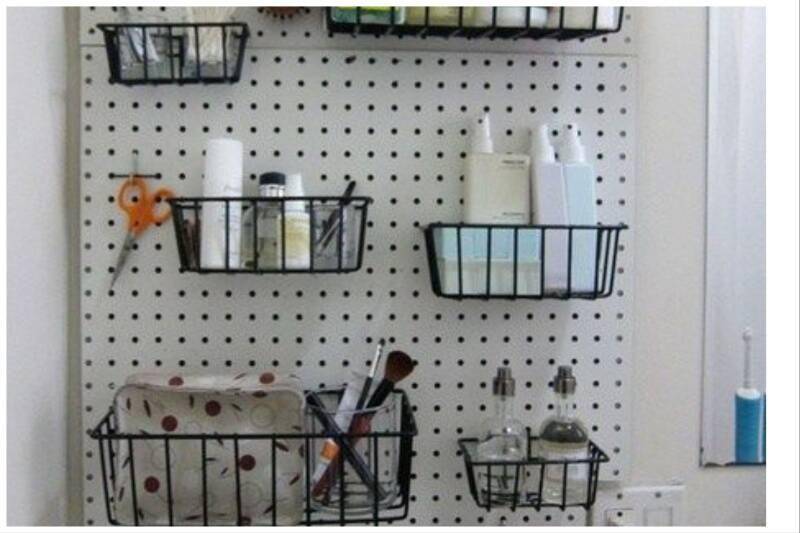 White pegboard with black baskets.