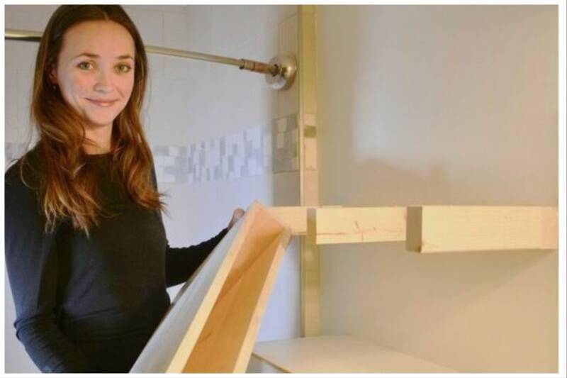 Woman holding wooden floating shelve.