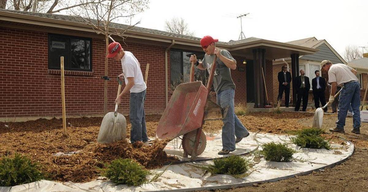 A landscaping crew from Prairie Snow Enterprises out of Keenesburg, CO, place mulch around new plants in front of a new HUD rehab home in Aurora