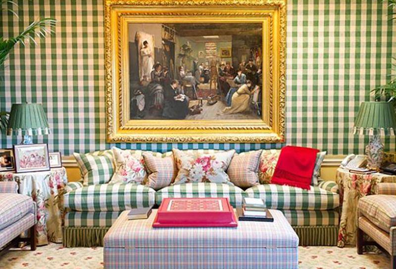 One of Oprah's living room has plaid walls, couches, and ottoman.