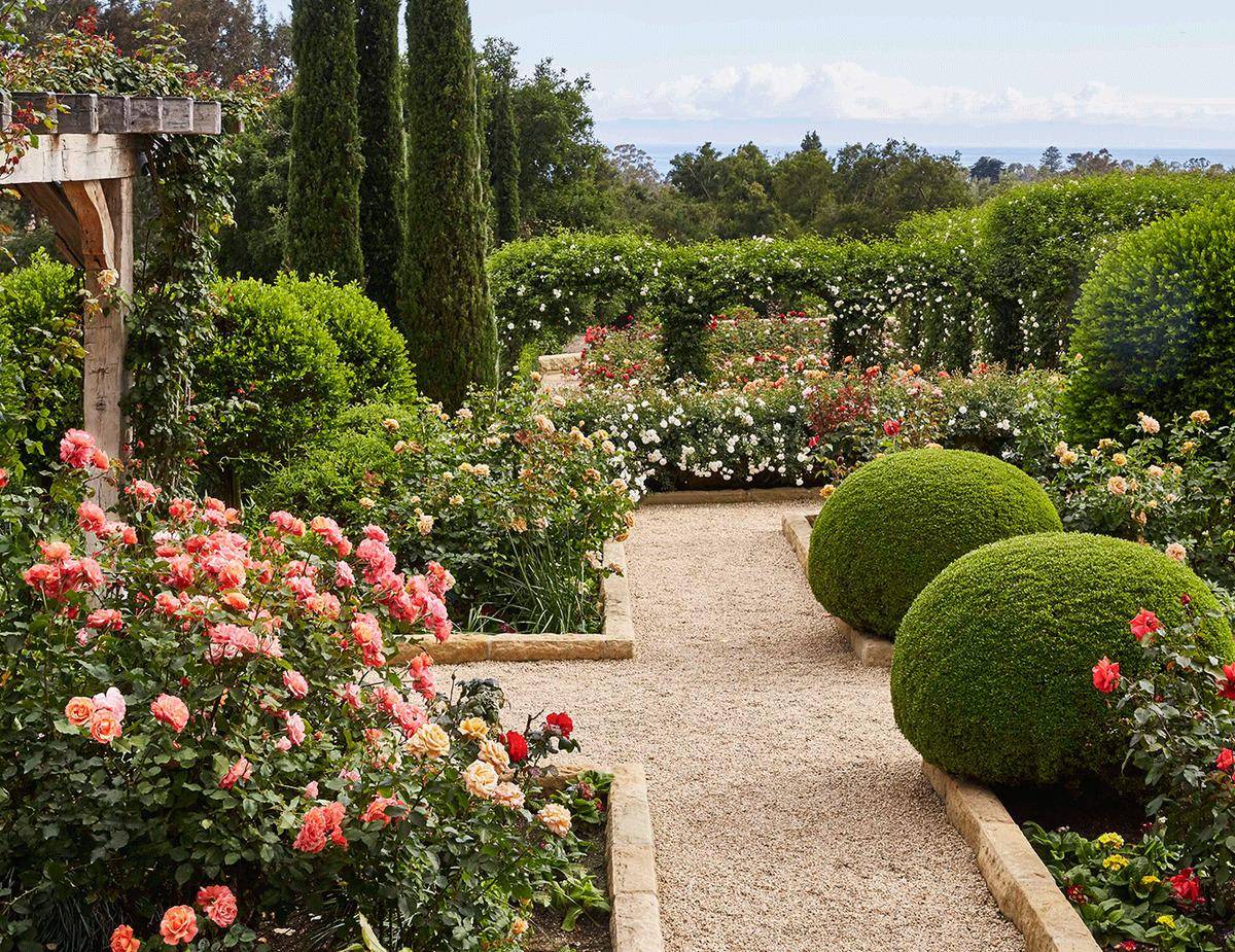 Oprah's garden features hedge arches, flowers, and wooden arches.