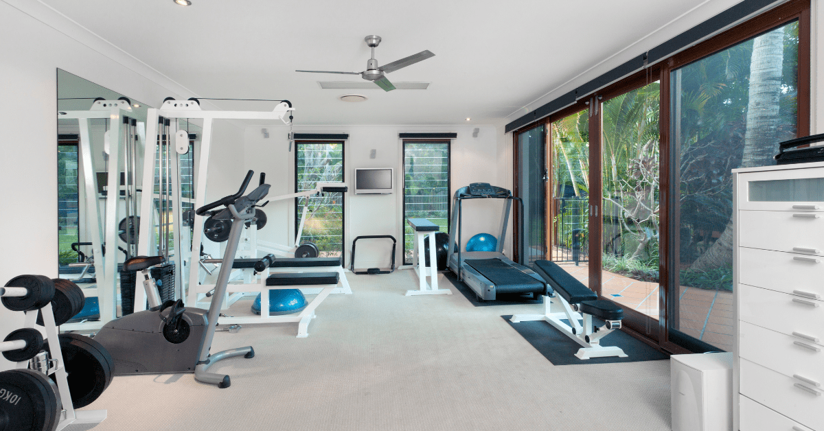 Spacious home gym with large windows.