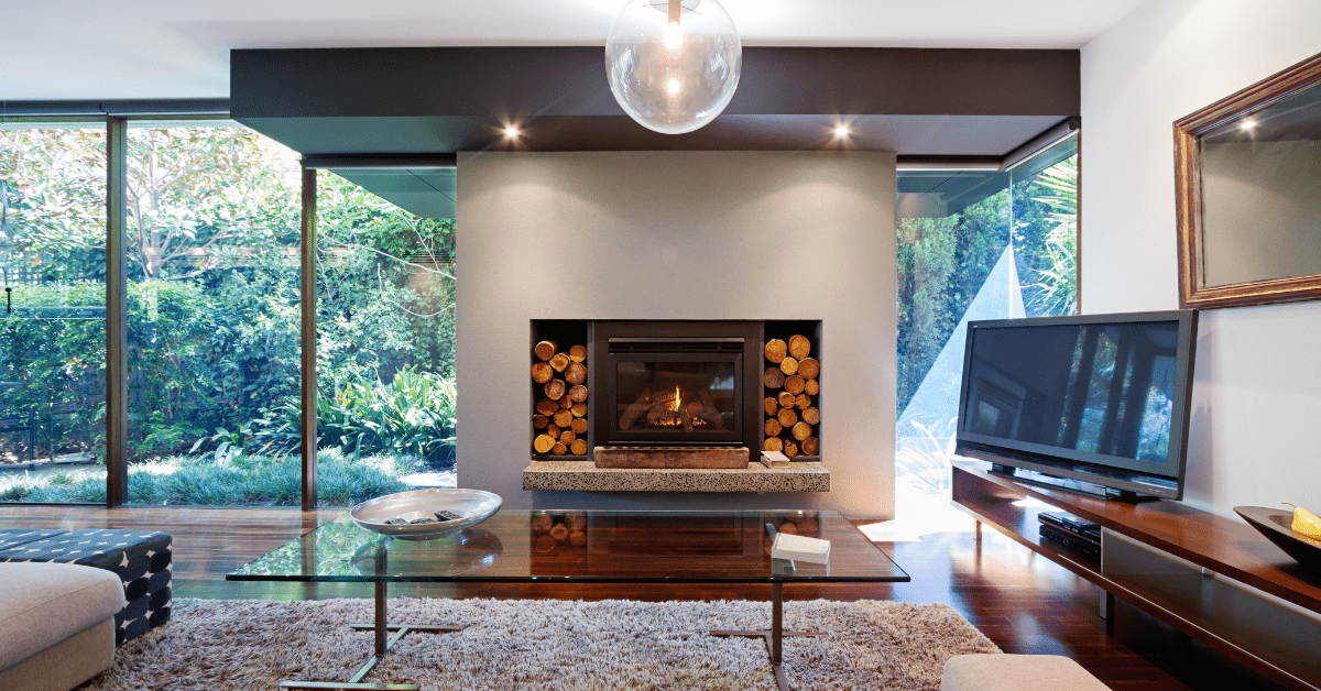 A wall built-in fireplace with wood logs surrounding it.