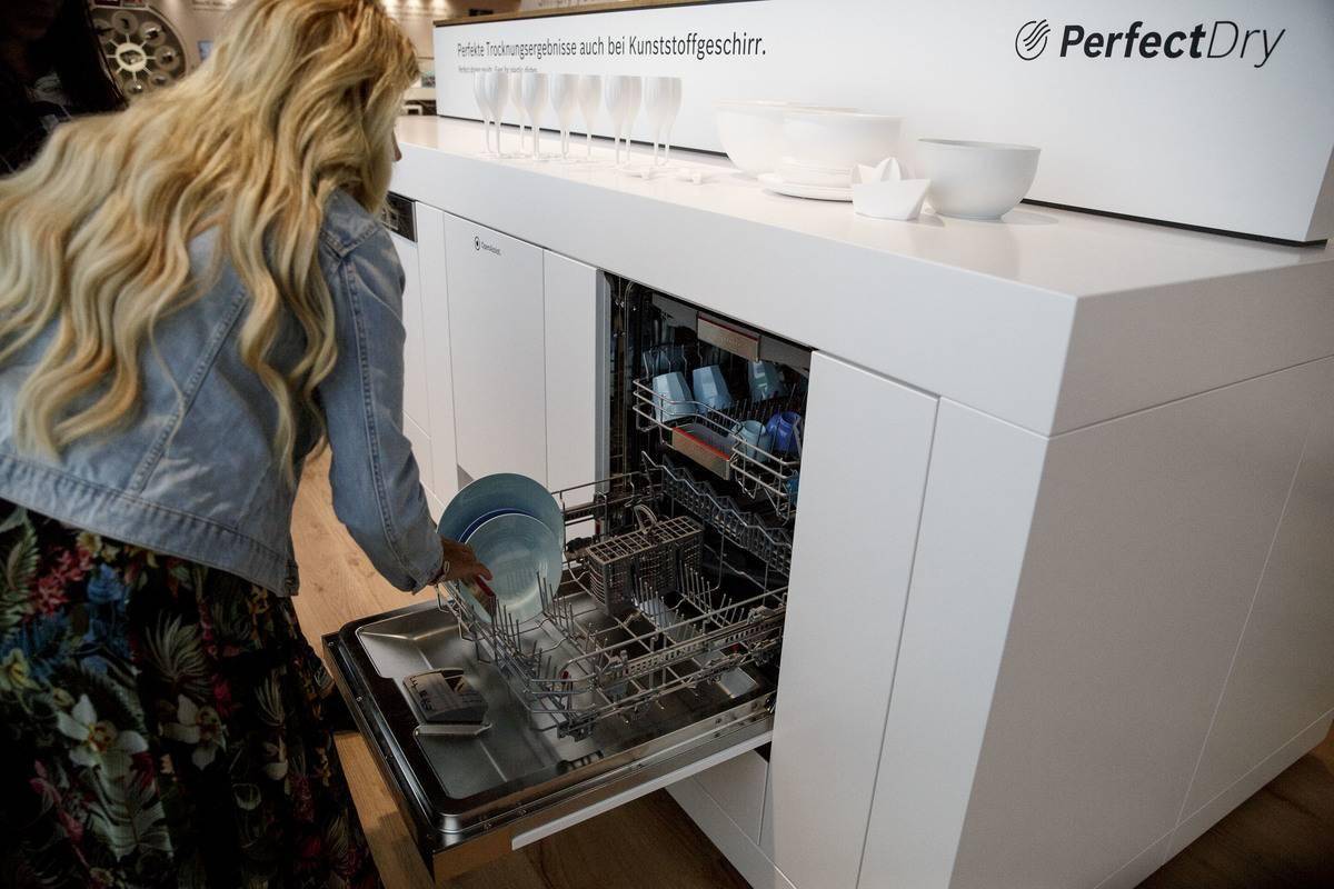 A woman loads her dishwasher.